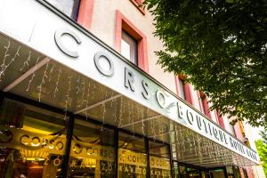 久洛Corso Boutique Hotel的建筑前有标志的商店