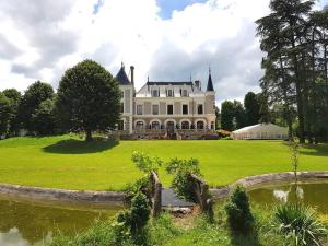 Saint-Paul-en-JarezEclosion Château Hôtel & Restaurant的一座白色的大房子,前面有一个池塘