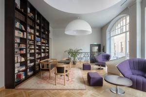 里加纳贝哥酒店的图书馆,配有紫色的椅子和桌子以及书架