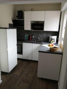 格奥尔格斯马林许特Ferienwohnung - Nadine的厨房配有白色橱柜和黑色台面