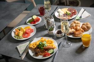 布达佩斯Cortile Hotel - Adults Only的餐桌,带食物盘和酒杯