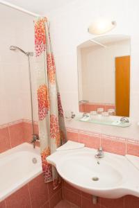阳光海滩Ivana Palace Hotel - Free Parking的一间带水槽、浴缸和镜子的浴室
