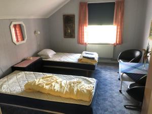 KrylboÄlvtomt的客房设有两张床、一把椅子和窗户。