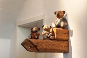BarkhagenGästehaus BärenHof的三个泰迪熊坐在一块木头上