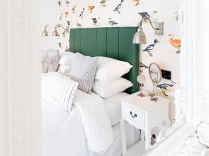 塔维斯托克The Cornish Arms的一间卧室配有一张带绿色床头板的床和一张边桌