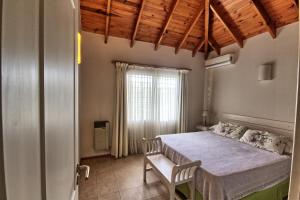 贝尔格拉诺将军镇Casas de Campo Henin Ecovilla & recreación infantil的一间卧室设有一张大床和一个窗户。