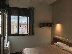 巴塞罗那Hostal Radio Barcelona的一间卧室设有一张床和一个窗口