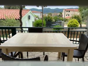 维甘Apartmani Ortolio的阳台配有一张木桌和两把椅子