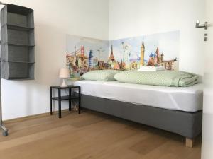 威斯巴登Townus Apartments Wiesbaden的卧室配有一张大床,墙上挂有绘画作品