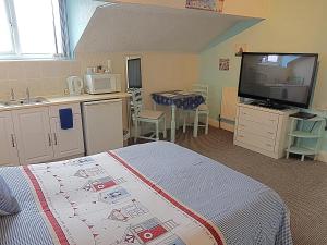 莱瑟姆-圣安妮Cumbria Guest House的一间卧室配有一张床,厨房配有水槽