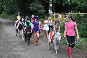 斯特灵韦斯菲尔德农场度假小屋的一群儿童骑着马在小径上