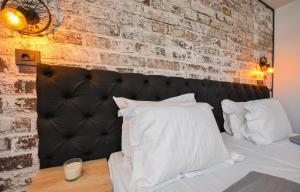 布加勒斯特豪华住宿公寓　的一间卧室设有砖墙和一张带白色枕头的床