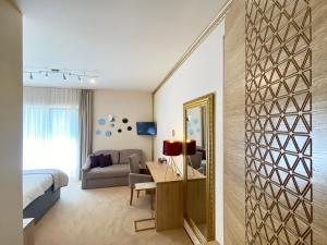 莫斯塔尔香格里拉大厦酒店的一间带一张床的卧室和一间带镜子的客厅