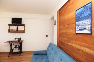特雷齐蒂利亚斯Hospedaria Brigite - Apartamento de Férias的客厅设有蓝色的沙发和木墙