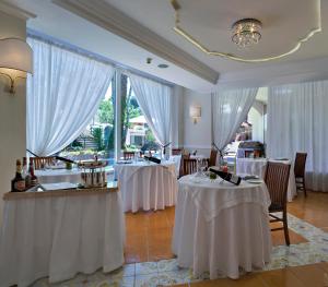 伊斯基亚马尔蓝光温泉酒店的餐厅设有2张带白色桌布的桌子