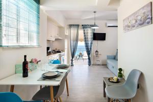 干尼亚Melina Apartments的厨房以及带桌椅的起居室。