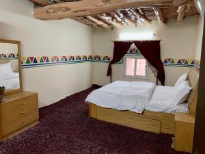 塔诺马بيت القرية التراثية的一间卧室设有一张大床和一个窗户。