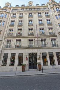 巴黎马尔加剧院别墅酒店的一座带窗户和旗帜的大型石头建筑