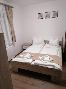 索瓦塔Jázmin Vendégház的一间卧室配有带白色床单和枕头的床。
