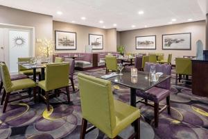 塔科马西雅图塔科马拉奎塔酒店及套房的用餐室配有桌子和绿色椅子