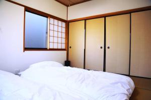 金泽Tsukuyomi Chuodori的卧室配有白色的床和窗户。