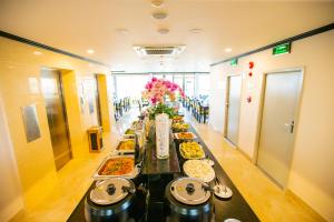 岘港Pharaoh Boutique Hotel Danang的一张长餐桌,上面有许多盘子的食物