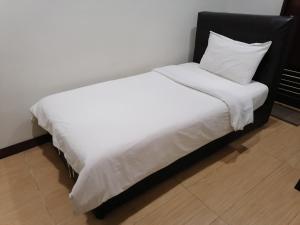 关丹法戈精品酒店的一张带黑色床头板和白色床单的白色床