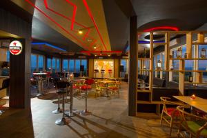 玛琅Ascent Hotel & Cafe Malang的一间带桌椅的餐厅和一间酒吧