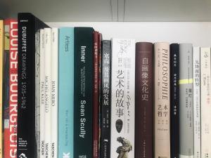 北京Zhe·Yi Boutique Guesthouse的书架上的一排书