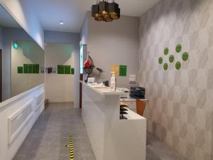 新加坡Q Loft Hotels at Bedok的浴室设有前台和绿色装饰。