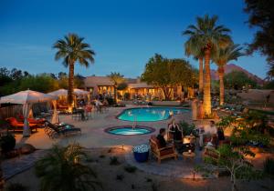 凤凰城艾尔摩酒店的一群人坐在度假村的游泳池周围