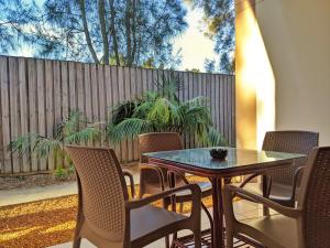 布里斯班诺维娜棕榈汽车旅馆的一个带桌椅和围栏的庭院