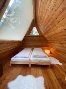 奥萨纳I Larici Camping Lodge的木制客房的一张床位,设有窗户
