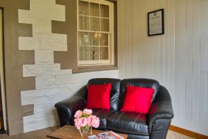 开普敦杰维斯BIG4 Cape Jervis Accommodation & Caravan Park的客厅里配有带红色枕头的真皮沙发