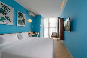 深圳深圳东门卡罗精品酒店（近罗湖口岸 / 国贸 / 东门）的卧室配有白色的床和蓝色的墙壁