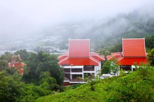 湄林清迈帕威曼Spa度假酒店的山顶上两座红色屋顶的建筑
