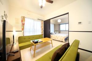 糸满EX Itoman Apartment 803的客厅配有绿色沙发和床。