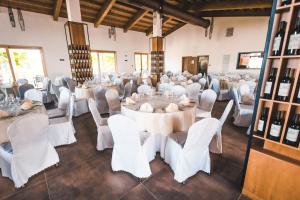 萨尔泰阿诺Agriturismo Le Anfore的宴会厅配有白色的桌椅