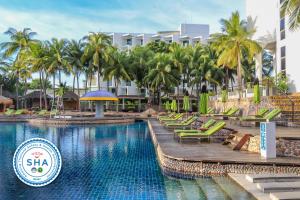 芭堤雅市中心Hard Rock Hotel Pattaya的一个带椅子和棕榈树的度假村游泳池