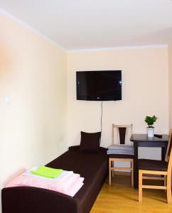斯蒂格纳Zajazd Nadmorski的卧室配有一张床,墙上配有电视。