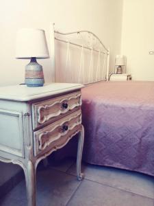 梅伦杜尼奥La Nuova Casetta的一间卧室配有一张床和一个带灯的梳妆台
