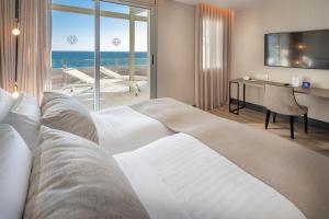 卡斯特尔德费尔斯贝莱尔酒店的酒店客房设有一张床,享有海景。