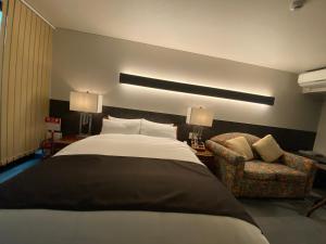 大阪Hotel 草石庵的一间卧室配有一张大床和一把椅子