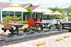 庆州叶津酒店的庭院里一组野餐桌和遮阳伞
