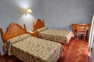莱斯普卢加德夫兰科利欧塞弗兰克利乡村酒店的酒店客房设有两张床和一张桌子。
