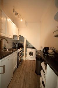 托基The garden flat的厨房配有水槽和洗衣机