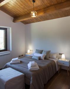 L'EspunyolaCasa Cal Saboya的配有白色墙壁和木制天花板的客房内的两张床