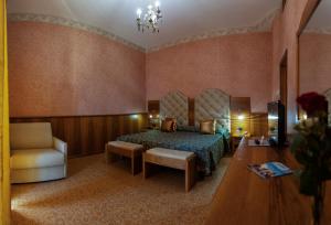 陶尔米纳陶尔米纳公园酒店的配有一张床和一把椅子的酒店客房