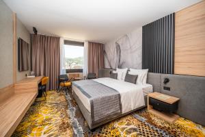 萨拉热窝假日酒店的配有一张床和一张书桌的酒店客房