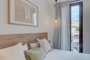 巴塞罗那快乐公寓的一间卧室设有一张床和一个美景窗户。